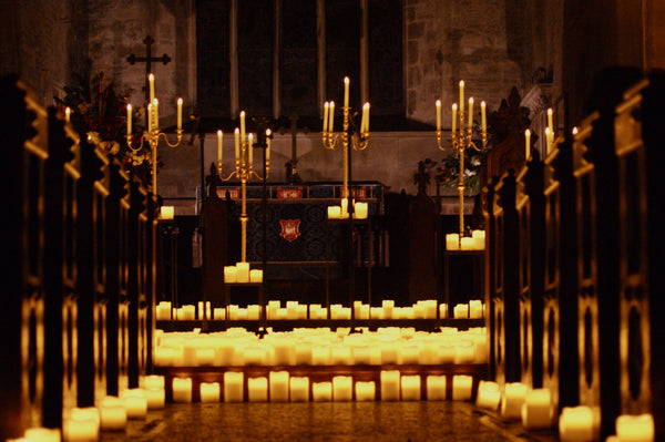 Hundreds of candles in a church, in between pews and on stage.