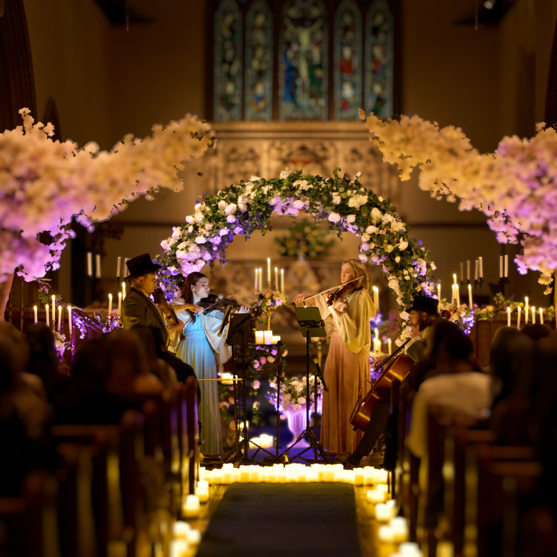 Orchestra performing in a decorated church with floral arches and candles.