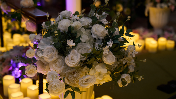 Bouquet of white flowers with candles in the background